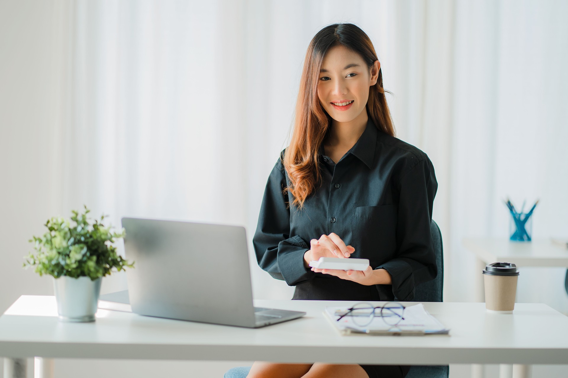 Femme d’affaires asiatique analysant un rapport pointant vers un graphique avec un stylo, un ordinateur portable et une calculatrice. En poste de travail, comptable, concept de marketing en ligne, e-commerce, image de paysage.